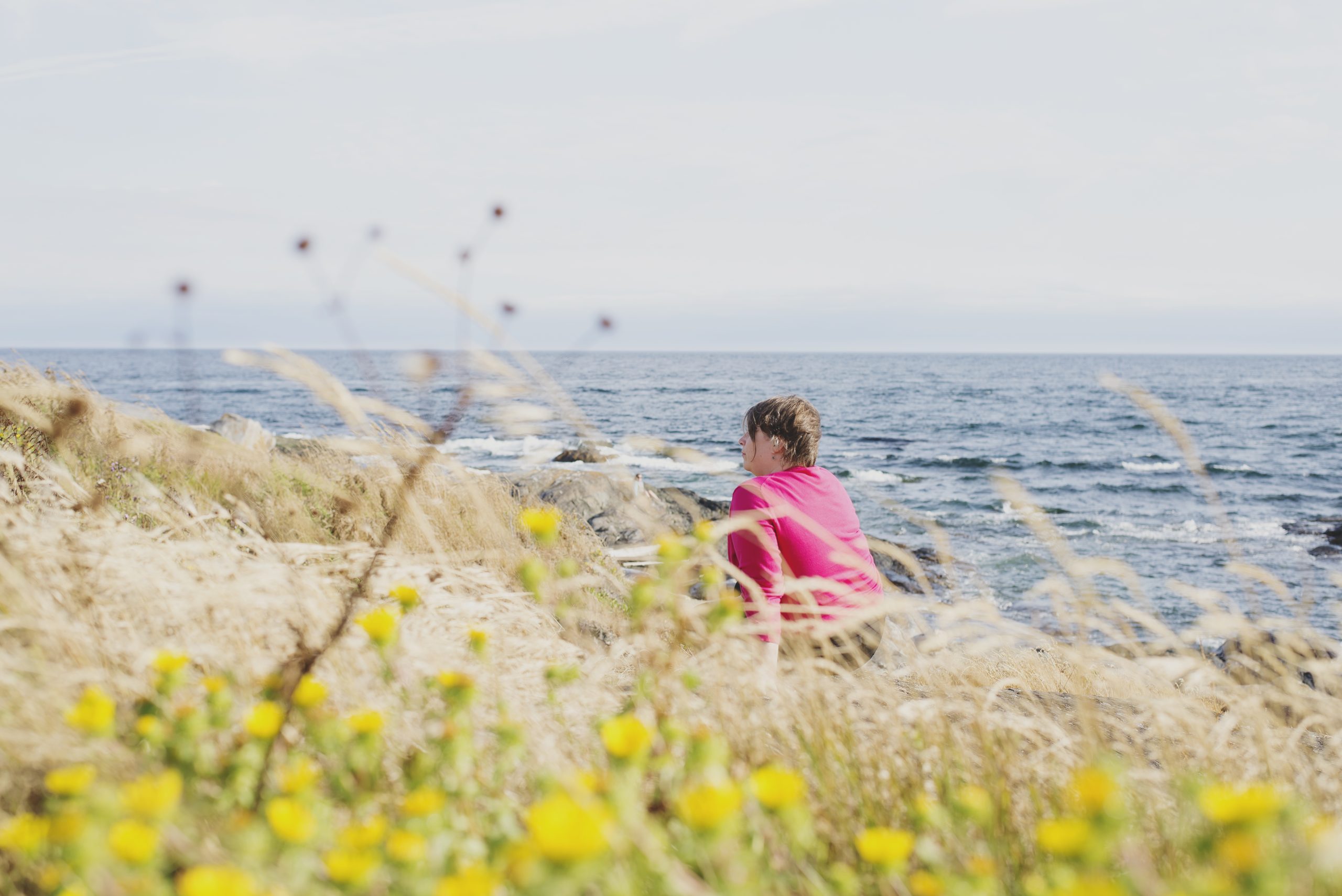 An image of Lisa, who offers Somatic Attachment Psychotherapy Training, sitting in a sunny field.